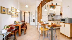 A modern kitchen with wooden accents, a dining area with a glass table, and a kitchen island.