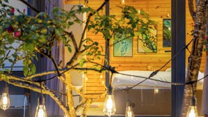 A cozy bedroom with a bed, wooden walls, and artwork. - JK Sapa Homestay & Swimming Pool (Sa Pa)