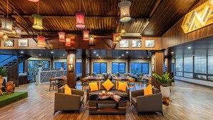 A spacious lobby with a central seating area, wooden flooring, and large windows offering views. - JK Sapa Homestay & Swimming Pool (Sa Pa)