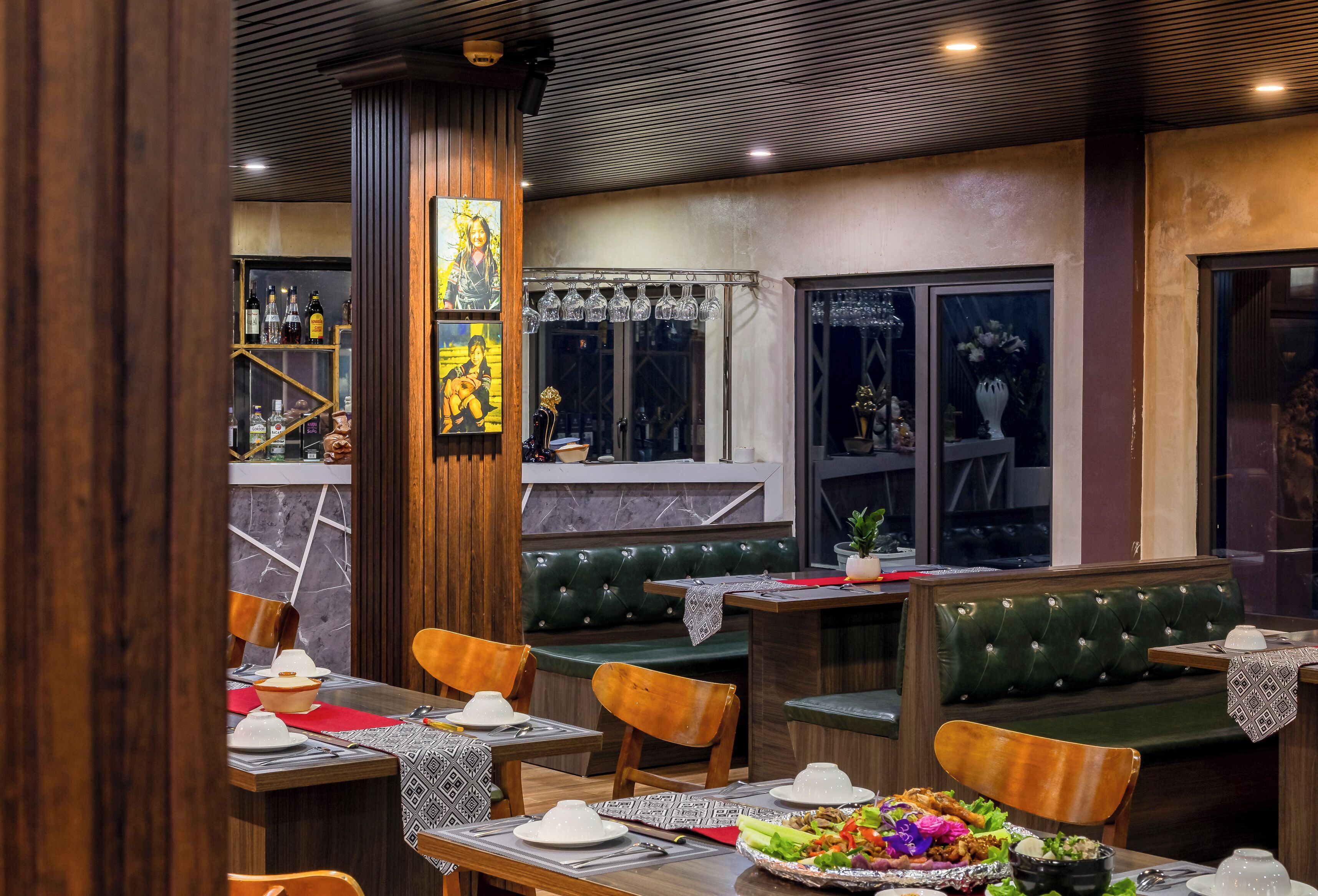 A restaurant interior with wooden furniture, a bar area, and a mural on the wall.