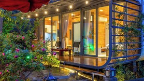 A modern house with a wooden deck, a small garden with flowers, and a lantern. - JK Sapa Homestay & Swimming Pool (Sa Pa)