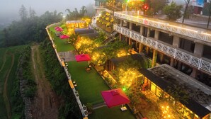 A multi-level hotel with outdoor seating areas, a covered walkway, and a view of the surrounding landscape. - JK Sapa Homestay & Swimming Pool (Sa Pa)