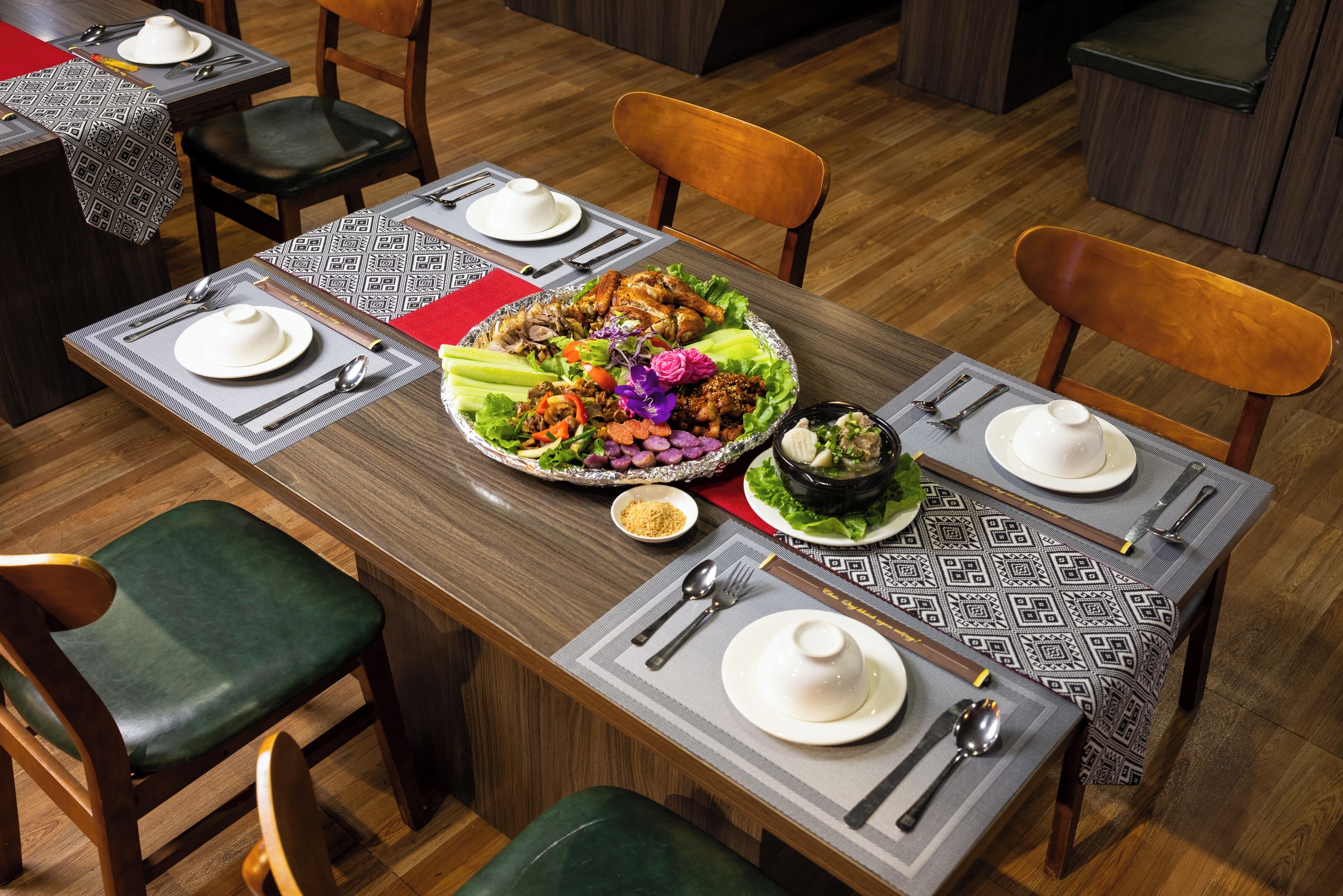 A dining area with a large table set for a meal, surrounded by chairs.