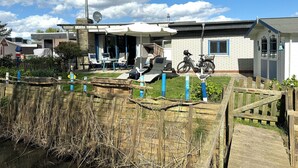 Ein Haus mit Terrasse, einem Fahrrad und einer Vogelstatue.