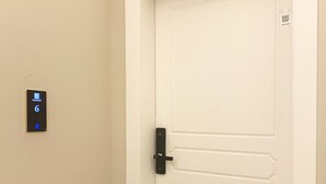Eine weiße Tür mit schwarzem Griff und einem digitalen Zahlenschloss, das die Zahl 6 anzeigt.
