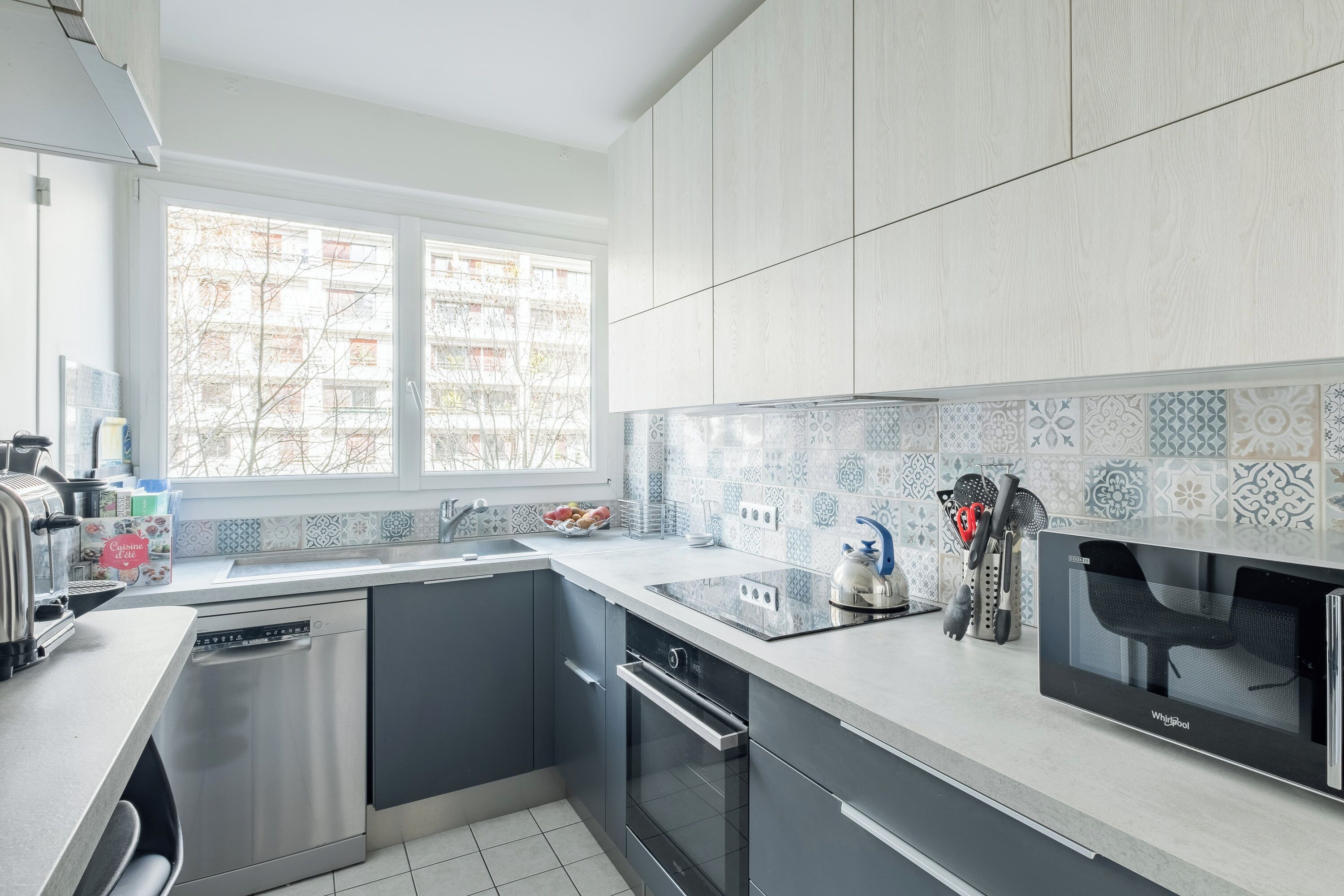 A modern kitchen with a dishwasher, oven, and microwave.