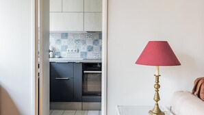Una cocina moderna con azulejos estampados en la salpicadera, horno empotrado y armarios oscuros.