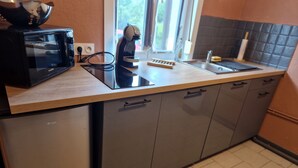 Una cocina equipada con microondas, cafetera y fregadero.