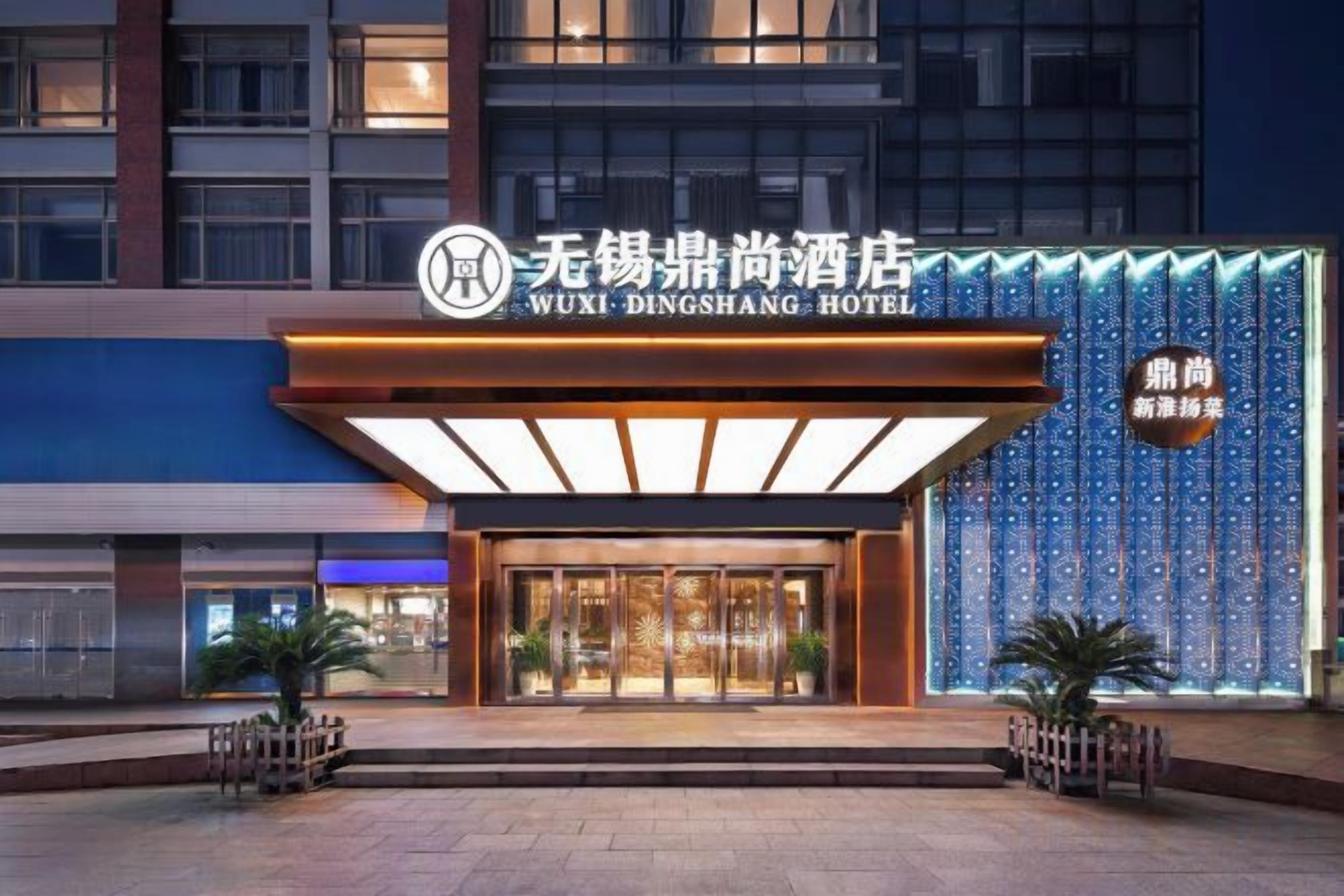 The exterior of the Wuxi Dingshang Hotel with a modern facade, large entrance doors, and a prominent sign.