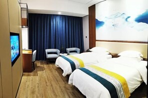 Habitación de hotel con dos camas, un escritorio, una silla, un televisor y un ventanal con vistas al cielo.