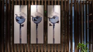 Three vertical panels with a fan and butterfly design, set against a wooden backdrop with vertical slats. - Dingshang Hotel (Wuxi)