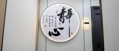 A wall-mounted sign with Japanese characters, a digital display, and a control panel.