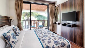 A hotel room with a large bed, a TV mounted on the wall, a balcony with a table and chairs, and curtains. - Riva Boutique Apartments (Alto de Porvorim)