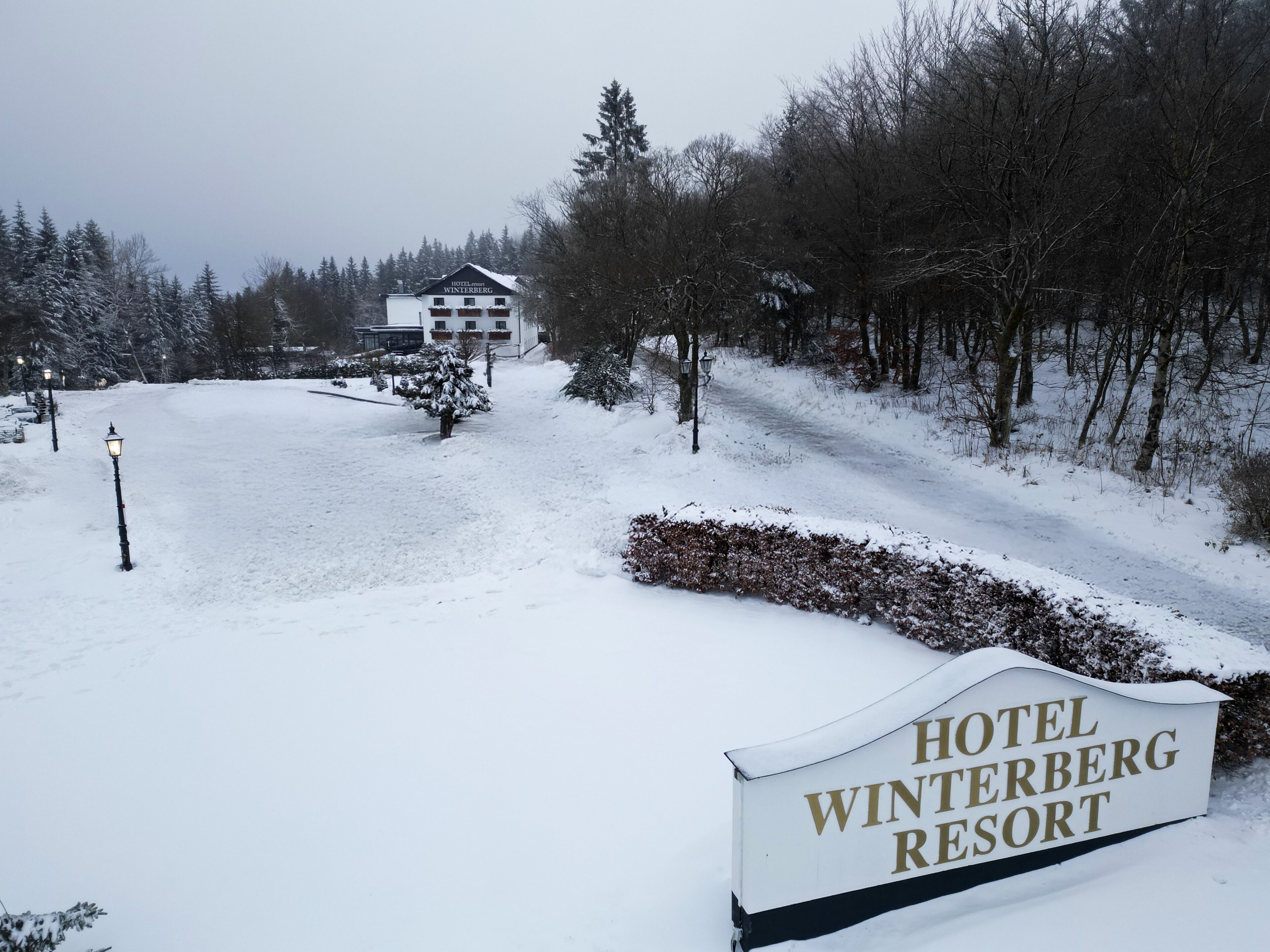 A snow-covered landscape with a sign for Hotel Winterberg Resort.