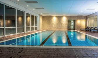 Una piscina techada, sillones reclinables de piscina