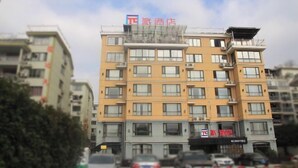 A multi-story hotel with a yellow facade, multiple balconies, and a sign indicating it is a hotel. - Pai Hotel (Xinchang Wanda Plaza store) (Xinchang)