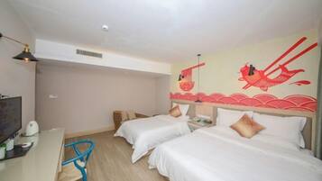 Habitación de hotel con dos camas, un escritorio, una silla y un mural en la pared.