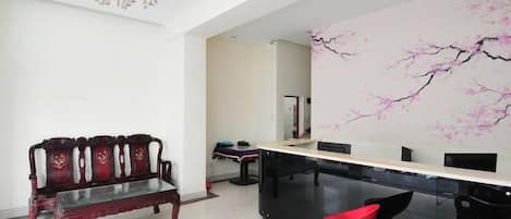A modern interior with a wooden bench, a red chair, and a black dining table.