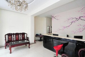 Un interior moderno con un banco de madera, una silla roja y una mesa de comedor negra.