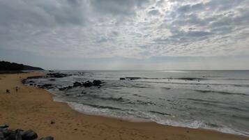 A beach with a rocky shoreline and a cloudy sky.
