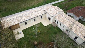 A large, single-story building with a tiled roof, a central courtyard, and a small garden area. - Maison Proche lac Hourtin et Océan (Gaillan-en-Médoc)