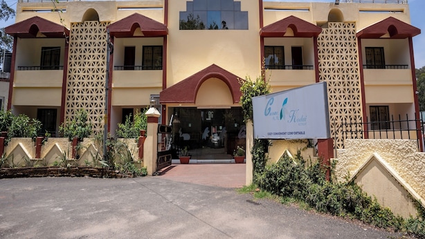 A hotel with a symmetrical facade, multiple balconies, and a central entrance.