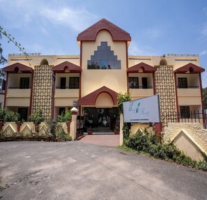A hotel with a symmetrical facade, multiple balconies, and a central entrance. - Kodai Retreat (Kodaikanal)