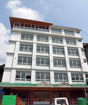 A multi-story building with a flat roof and a series of windows on each floor.