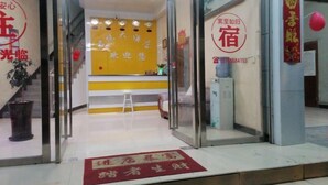 A hotel reception area with a yellow wall, a reception desk, and a staircase leading to an upper floor. - Grand Hyatt Sansui (Sansui)