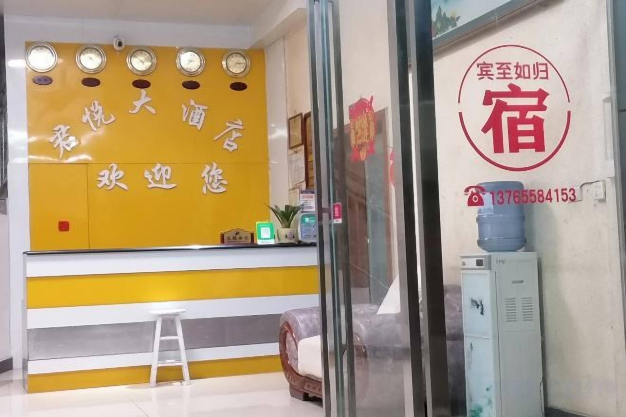 A reception area with a yellow counter, a white stool, and a water dispenser.