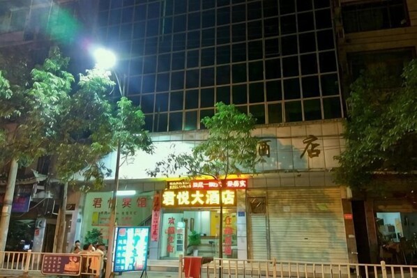 A building with a closed shutter, a sign with Chinese characters, and a tree in front. - Grand Hyatt Sansui (Sansui)