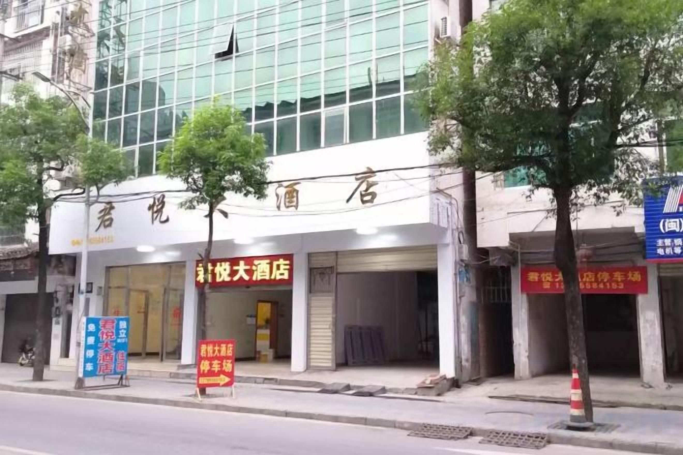 Fachada de hotel con señalización para un hotel grande y un servicio de alquiler de coches.