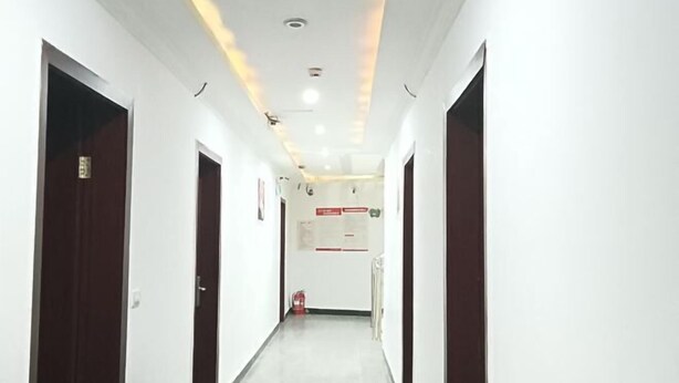 A narrow, well-lit hallway with white walls and dark wooden doors. - Grand Hyatt Sansui (Sansui)