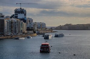 A coastal cityscape with a prominent building labeled 'bet365' and a red double-decker bus in the foreground. - Enjoy a stylish stay just steps from Sliema Ferries! Spacious apartment for up to 8 guests with stunning harbour views — perfect for a relaxing Malta getaway (Tas-Sliema)