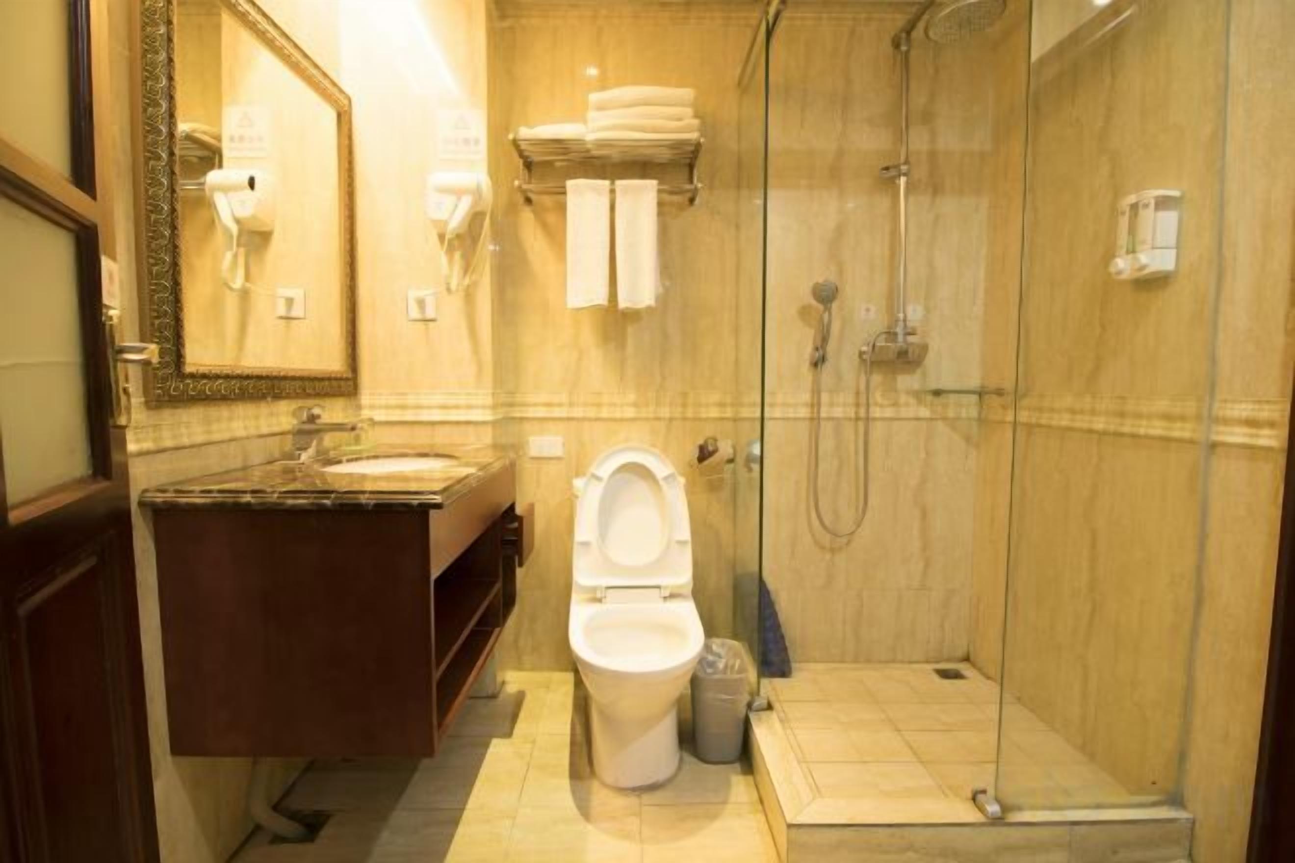 Un baño con inodoro, lavamanos y ducha.