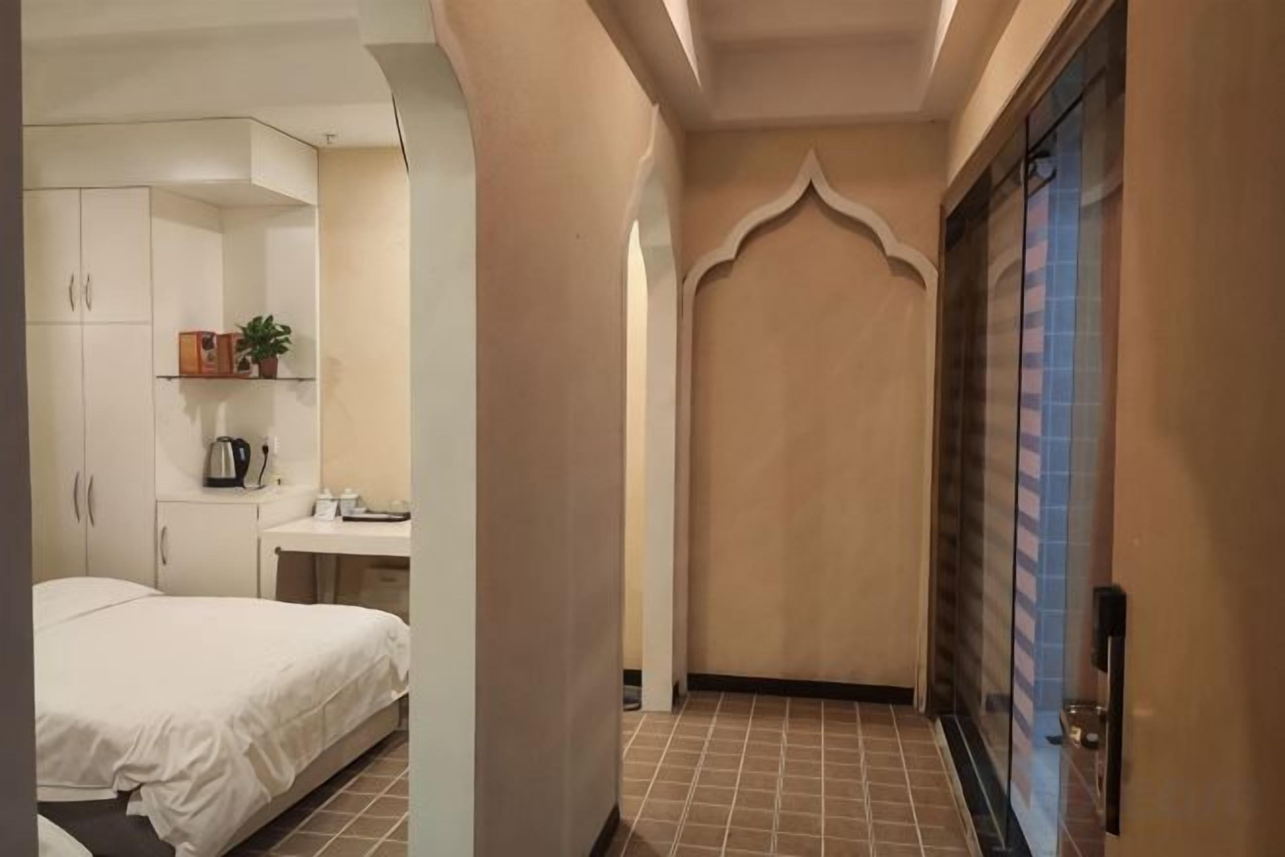Una camera d'albergo con un letto, una scrivania, una sedia e un armadio.