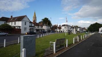 A street with traditional buildings, a church spire, and a flagpole.