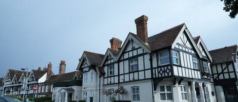 A traditional Tudor-style building with a prominent chimney, white and black timber framing, and a sign indicating it is the Manor Hotel.