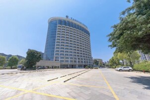 Un hotel con fachada curva, techo plano y cielo despejado.