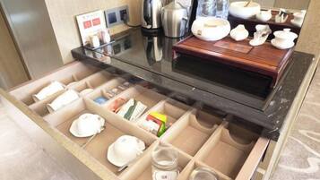 Habitación de hotel con minibar, cafetera, hervidor de agua y tetera.