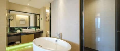 A modern bathroom with a freestanding bathtub, a large mirror, and a glass shower enclosure.