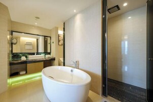Un baño moderno con una bañera independiente, un espejo grande y un box de ducha de vidrio.