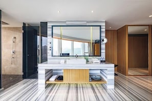 A modern bathroom with a large mirror, a marble countertop, and a shower area. - Fanhua Hotel (Quanzhou)