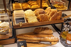 A bakery display with various breads and pastries. - Hôtel Gabbie (Paris)