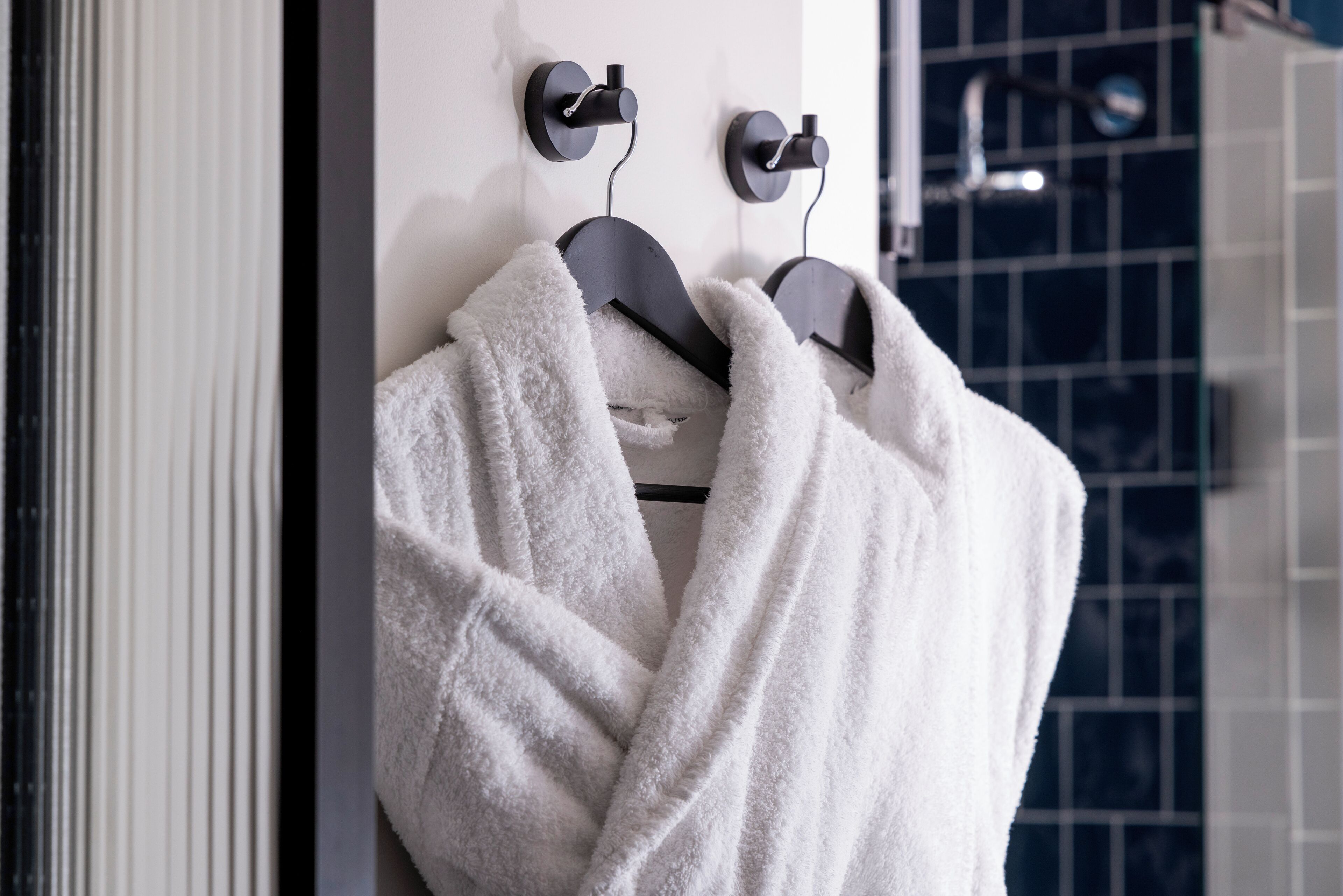 A bathroom with a towel rack holding two white towels.