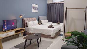 A modern bedroom with a bed, bedside table, TV, and a ceiling fan.