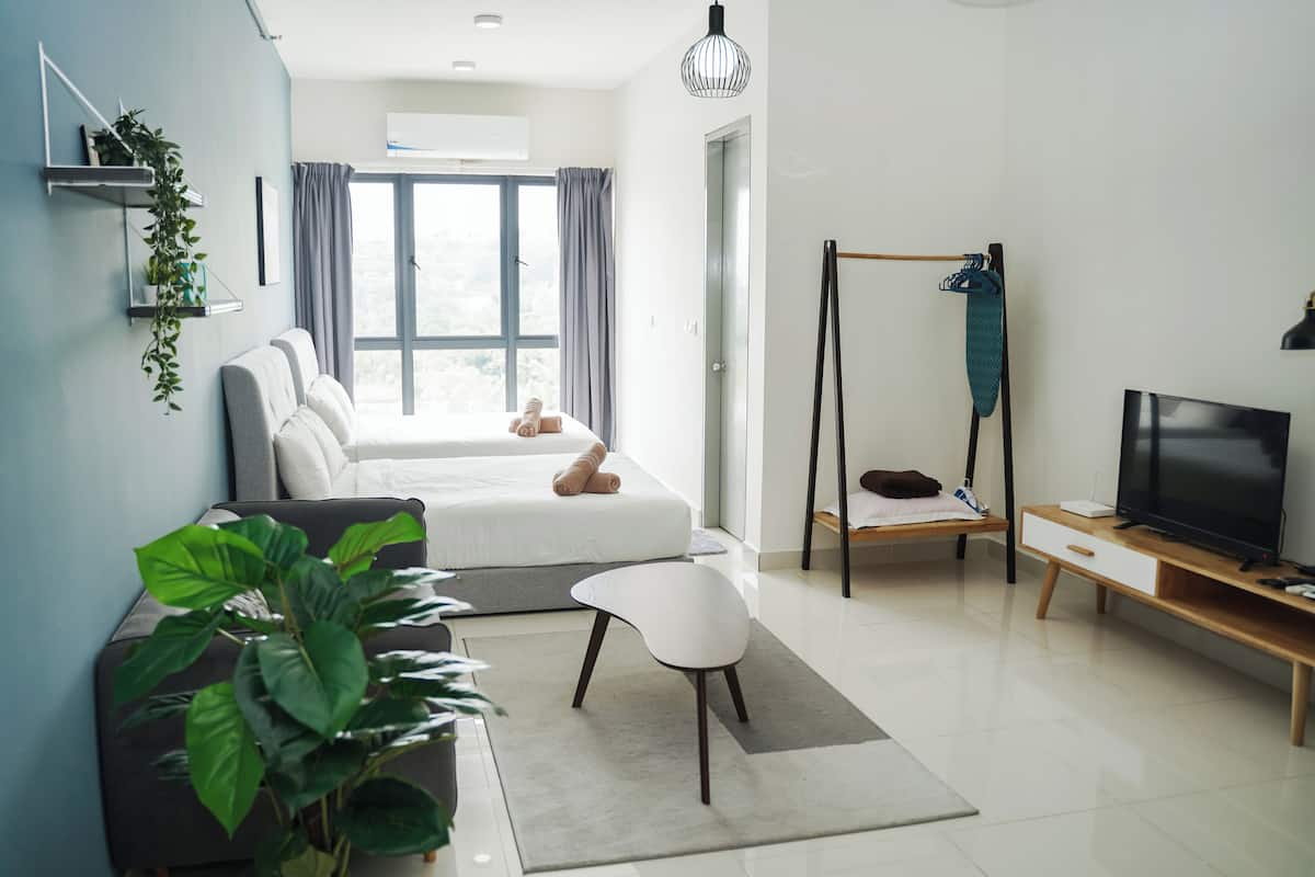 A modern living room with a sofa, a TV, a swing, and a large window.