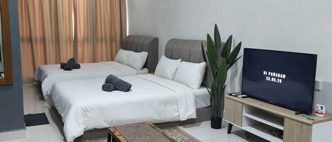 Una habitación de hotel moderna con una cama, televisión, una mesita y un tapete decorativo.