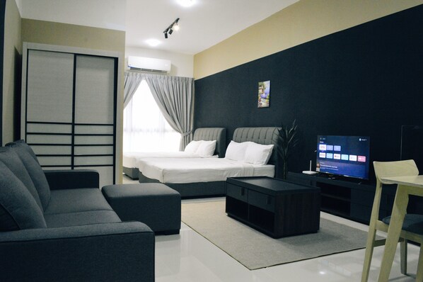 A modern hotel room with a bed, sofa, TV, and a desk. - KLIA AIRPORT HOMESTAY (Sepang)