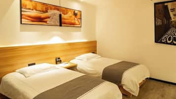 A hotel room with two beds, a wooden headboard, a nightstand, and two wall-mounted artworks.